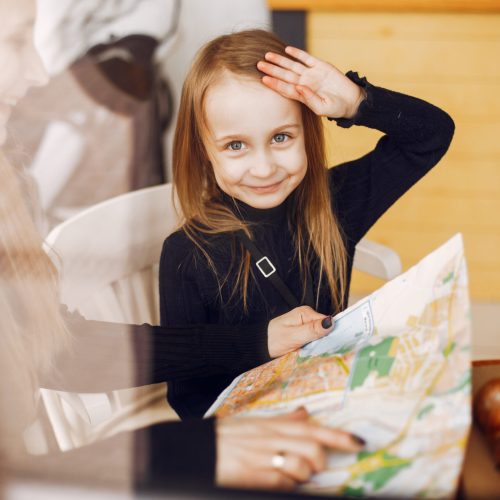 Fashionable mother with daughter. Family in a cafe. Girl with a croisant